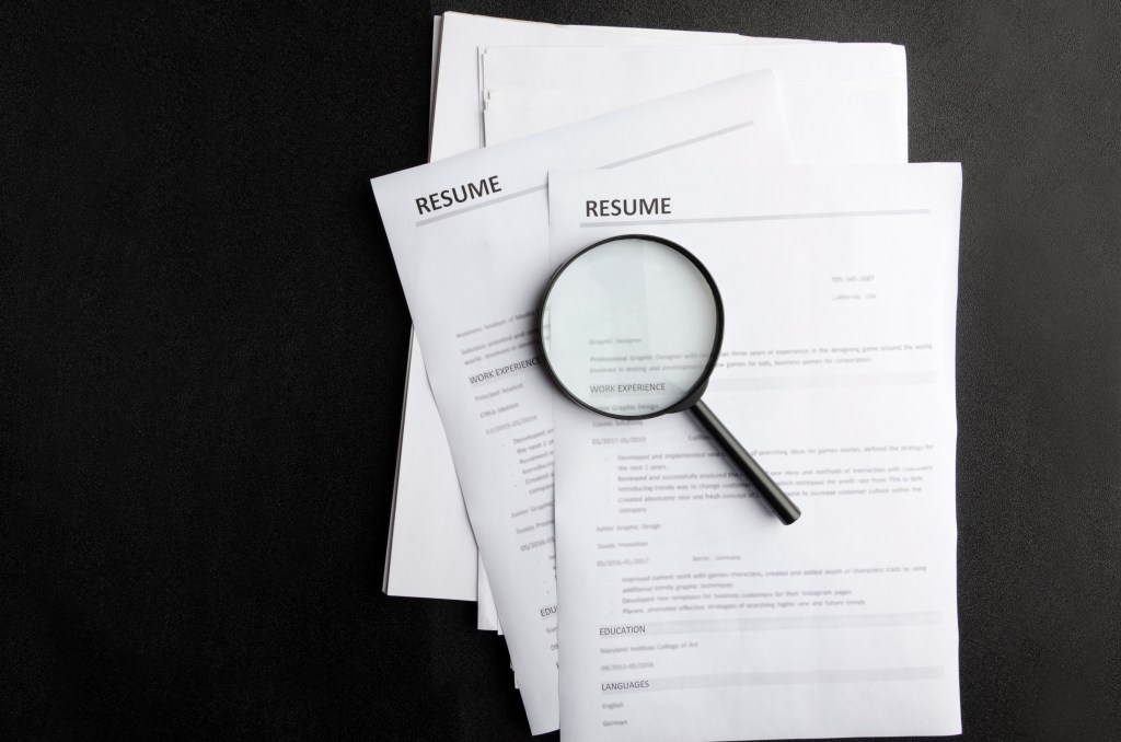 Image of resume with magnifying glass.